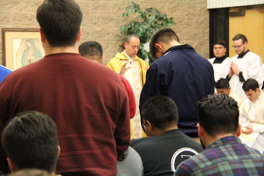 Fr. Paul Sullivan, director of vocations for the Diocese of Phoenix, prays over young men who said they felt called to a religious vocation during a young men's conference Jan. 2. (CATHOLIC SUN)