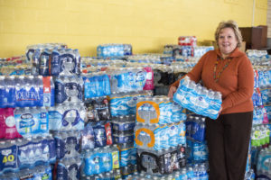 Vicky Schultz, president and CEO of Catholic Charities of Shiawassee and Genessee counties in Flint, Mich., displays some of the bottled water Jan. 19 that has been donated to help Flint residents whose water has been contaminated with lead. Michigan Gov. Rick Snyder said he has failed Flint residents but pledged to take new steps to fix the city's drinking water crisis, starting with committing millions in state funding. (CNS photo/Jim West)