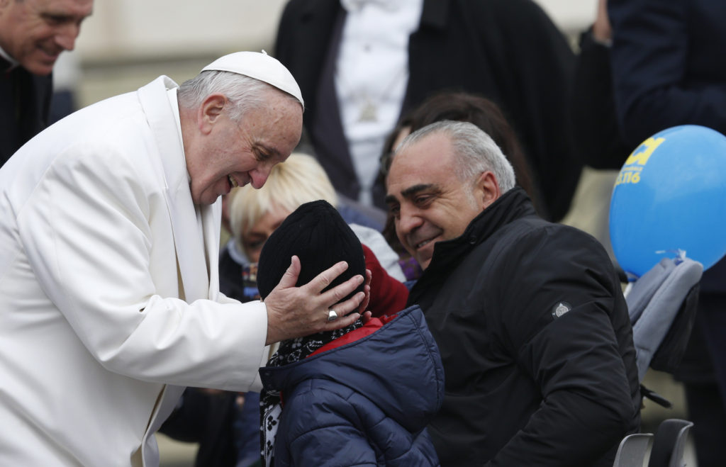 Pope Francis greets a child while meeting the disabled during a special audience for the Holy Year of Mercy in St. Peter's Square at the Vatican Jan. 30. (CNS photo/Paul Haring)