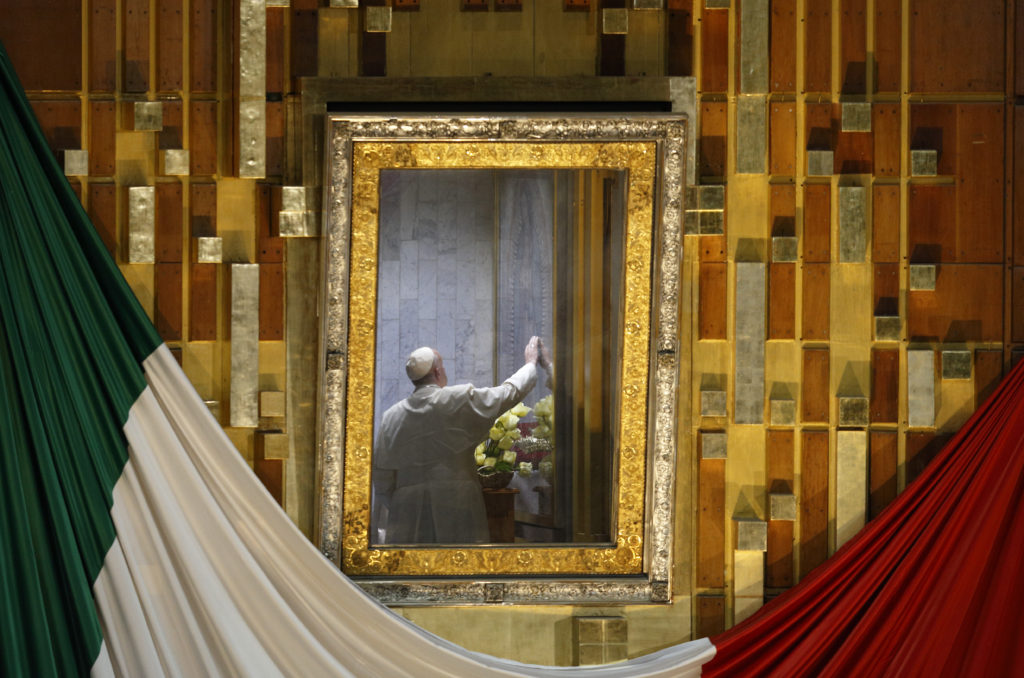 Pope Francis touches the original image of Our Lady of Guadalupe after celebrating Mass in the Basilica of Our Lady of Guadalupe in Mexico City Feb. 13. The Marian image was rotated for the pope to pray in the "camarin" ("little room") behind the main altar. (CNS photo/Paul Haring)