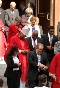 Washington Auxiliary Bishop Martin D. Holley, in red vestments, chats with U.S. Supreme Court Justice Clarence Thomas following the annual Red Mass at the Cathedral of St. Matthew in Washington Oct. 5. Also pictured is U.S. Supreme Court Justice Antonin Scalia, lower center right. The Mass traditionally marks the start of the court year, including the opening of the Supreme Court term. (CNS photo/Jonathan Ernst, Reuters) 