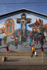 A man walks past a mural near Sacred Heart Church in Segundo Barrio in El Paso, Texas, Feb. 13. The mural depicts the history of the parish, which is located a few blocks from the border with Mexico. Pope Francis will celebrate Mass Feb. 17 in Ciudad Juarez, just over the border. (CNS photo/Nancy Wiechec)