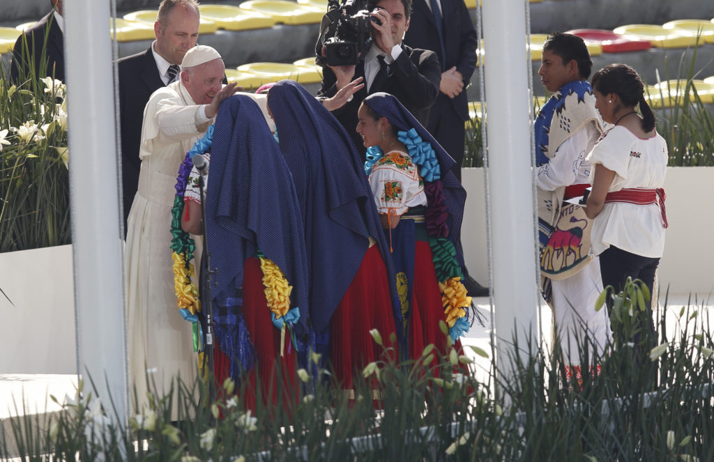 Pope Francis greets girls in traditional dress during a meeting with young people at the Jose Maria Morelos Pavon Stadium in Morelia, Mexico, Feb. 16. (CNS photo/Paul Haring)
