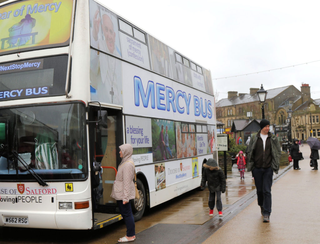 People walk by the Mercy Bus in Burnley, England, Feb. 20. The double-decker bus is used for priests to hear the confessions of people who have stopped going to church. (CNS photo/Simon Caldwell) 