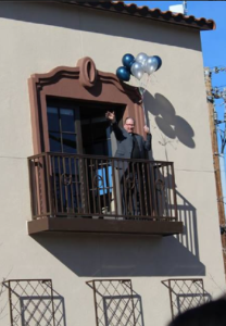 Jesuit Father Dan Sullivan, pastor of St. Francis Xavier Parish and School, greets students from his office balcony Jan. 21 while holding birthday balloons. (photo from school Facebook page)