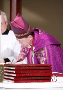 Bishop Thomas J. Olmsted signs each parish's Book of the Elect Feb. 14. (Ambria Hammel/CATHOLIC SUN)