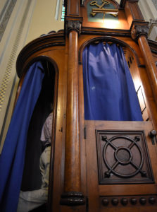 A man makes his confession in a confessional booth at Old St. Mary's Church in Detroit Feb. 29. (CNS photo/Mike Stechschulte, The Michigan Catholic) 