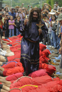 A man playing Jesus walks on the backs of "demons" during a Holy Week celebration in Texistepeque, El Salvador, in this April 18, 2011, file photo. Police in some Salvadoran cities have begun patrolling in an effort to prevent violence during Holy Week. (CNS photo/Roberto Escobar, EPA) 