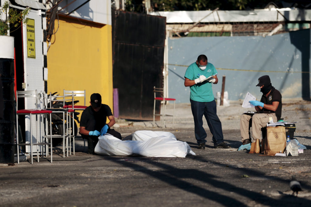 Police and forensic technicians process a crime scene where four people were killed in San Salvador, El Salvador, Feb. 17. Police in some Salvadoran cities have begun patrolling in an effort to prevent violence during Holy Week. (CNS photo/Jose Cabezas, Reuters) 