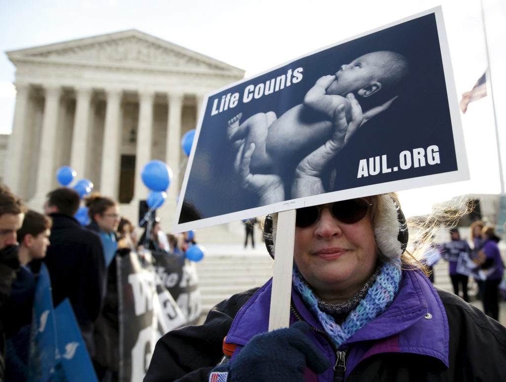 A pro-life supporter holds up a sign in front of the U.S. Supreme Court in Washington March 2. Meg McDonnell, executive director of Women Speak for Themselves, was making preparations for a March 23 rally outside the Supreme Court during oral arguments on the contraceptive mandate case. (CNS photo/Kevin Lamarque, Reuters) 
