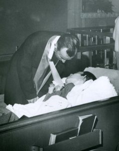 Fr. Eugene O’Caroll give first Holy Communion to a disabled student in this 1967 file photo. (Diocese of Phoenix Archives)