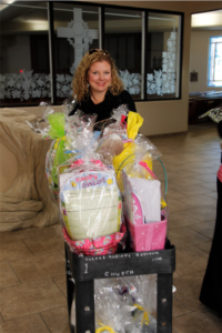 Alison Devereux-Naumann, president of St. Gerard Circle, pushes a cartload of Easter baskets for children in the community. (Ambria Hammel/CATHOLIC SUN)