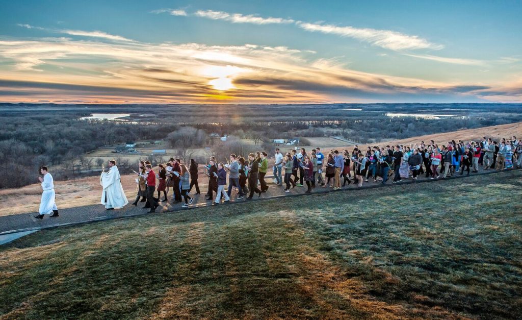 At sunset University of Mary students process across campus on Sageway overlooking the majestic Missouri River Valley to Palm Sunday Mass in this file photo. (courtesy photo)