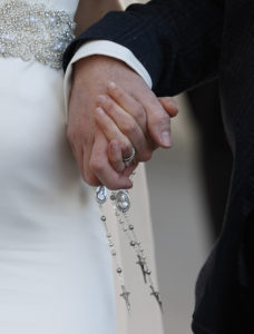 A newly married couple hold rosaries in their hands as they leave Pope Francis' general audience in St. Peter's Square at the Vatican Feb. 24. Pope Francis' postsynodal apostolic exhortation on the family, "Amoris Laetitia ("The Joy of Love)," was released April 8. (CNS photo/Paul Haring)