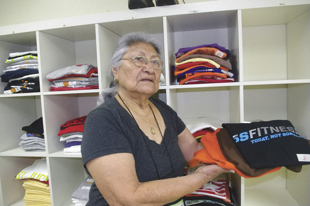 Aurora Hernandez waits for her latest client to finish showering at St. Vincent de Paul's main campus in downtown Phoenix where she hands out clean clothing to the homeless and vulnerable. "We're doing God's work," she said.