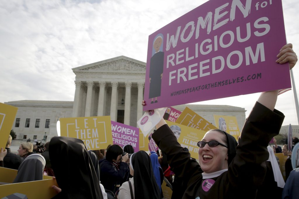 A religious sister displays a sign as she and others protest the Affordable Care Act's contraceptive mandate March 23  outside the U.S. Supreme Court in Washington. The court heard oral arguments in the Zubik v. Burwell mandate case. (CNS photo/Joshua Roberts, Reuters)