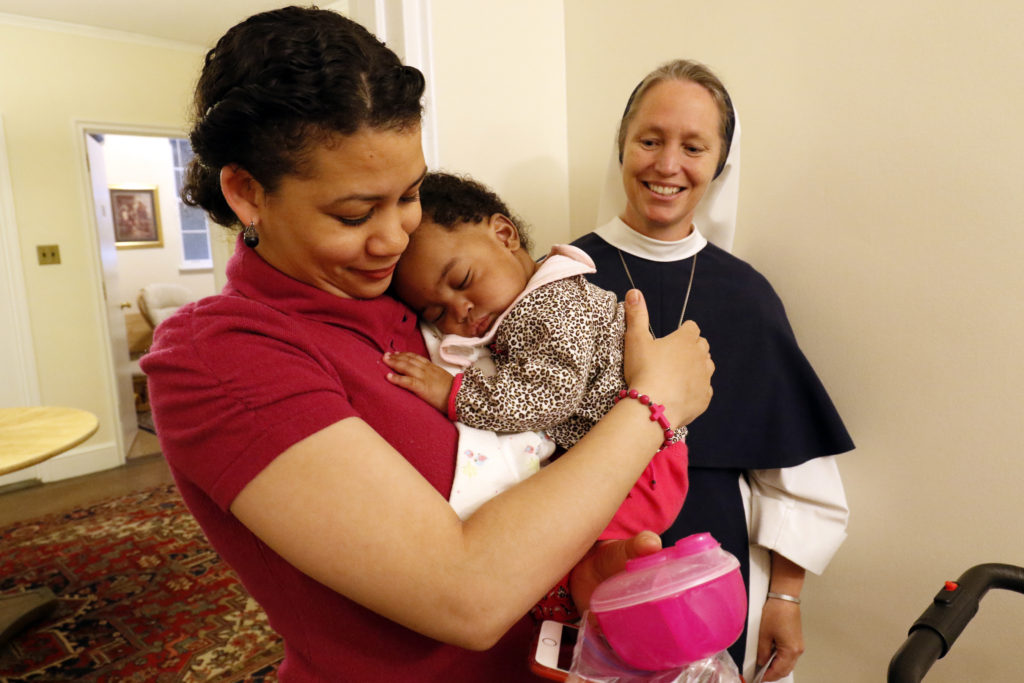 Claudia Gutierrez holds her six-month-old daughter Esther  as Sr. Mary Elizabeth, vicar general of the Sisters of Life, looks on May 4 at the religious community's Holy Respite residence in the Hell's Kitchen neighborhood of New York City. Holy Respite serves as a home and support center for pregnant women in crisis and new mothers. (CNS photo/Gregory A. Shemitz) 