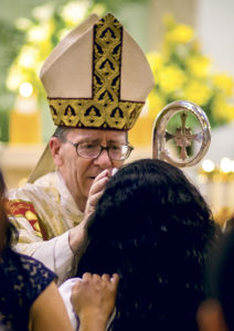 Bishop Thomas J. Olmsted confirms a young woman at Most Holy Trinity Parish May 4. Faith formation leaders say the confirmandi understand the Holy Spirit's gifts. (Billy Hardiman/CATHOLIC SUN)