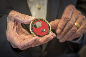 Kirk Lanterman holds Challenge Coin presented to him by University of Mary's Dave Anderson as a token of appreciation for his generous donation to help provide new undergraduate military scholarship. (Photo courtesy of University of Mary)