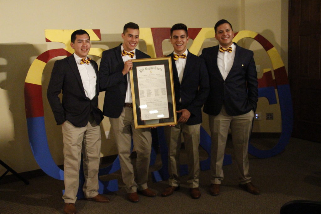 Several founding members, including Edward Flore, second from left, pose with the chartering document for Phi Kappa Theta's newest chapter May 7 at the All Saints Catholic Newman Center. (Ambria Hammel/CATHOLIC SUN)