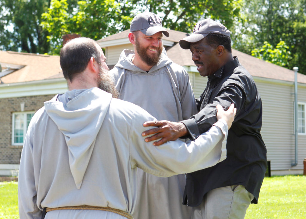 Franciscan Friars of the Renewal from New York talk with Sonny Fishback, a long-time friend of Muhammad Ali, as they pay their respects to Ali, the former world heavyweight boxing champion outside his childhood home in Louisville, Ky. Ali died June 3 at age 74 after a long battle with Parkinson's disease. (CNS photo/John Sommers II, Reuters) 