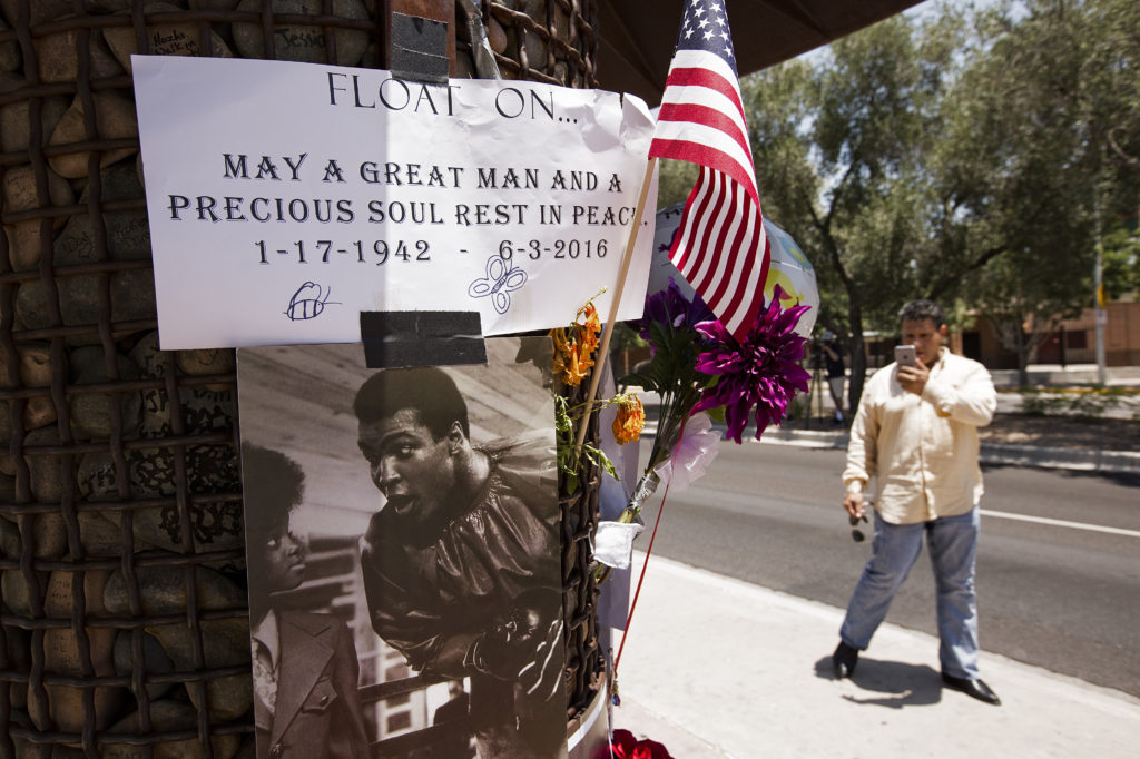 A man stops to take a photo and pay his respects at a pop-up memorial to Muhammad Ali June 5 outside the Scottsdale, Ariz., hospital where Ali died June 3. The legendary American boxer, known as "The Greatest," was remembered in Phoenix for his spirit, generosity and strength in his struggle with Parkinson's disease. (CNS photo/Nancy Wiechec) 