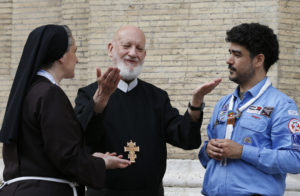 Redemptorist Father Cyril Axelrod, who is deaf and blind, speaks to Franciscan Sister Veronica Donatello and scout Orazio Pemmisi, who is deaf, outside Chiesa Nuova in Rome June 10. The South African priest, who travels the world ministering to deaf Catholics, said that sign language, tactile sign language and body language are "gifts of the Holy Spirit." He was in Rome for the Year of Mercy jubilee celebration for the sick and persons with disabilities. (CNS photo/Paul Haring) 