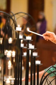 A participant of the "Vigil to Dry Tears" lights a candle June 13 at St. James Cathedral in Orlando, Fla., for victims of a mass shooting at Pulse nightclub in Orlando. The event gathered interfaith leaders and some 500 people from all walks of life for prayer, music, scripture and reflection. (CNS photo/Andrea Navarro, Florida Catholic) See ORLANDO-PRAYER-VIGIL June 14, 2016.
