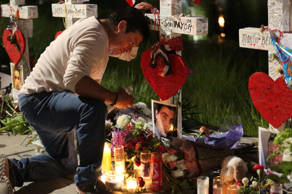 Jose Louis Morales cries as he kneels June 21 at a makeshift memorial for his brother Edward Sotomayor Jr. and other victims of the Pulse night club shootings in Orlando, Fla. (CNS photo/Carlo Allegri, Reuters)