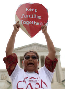 A protester holds a placard reading "Keep Families Together!" during a rally outside the Supreme Court in Washington June 23. The justices issued a 4-4 decision in the immigration case United States v. Texas, leaving a lower court ruling blocking President Barack Obama's executive actions. (CNS photo/Andrew Gombert, EPA) 
