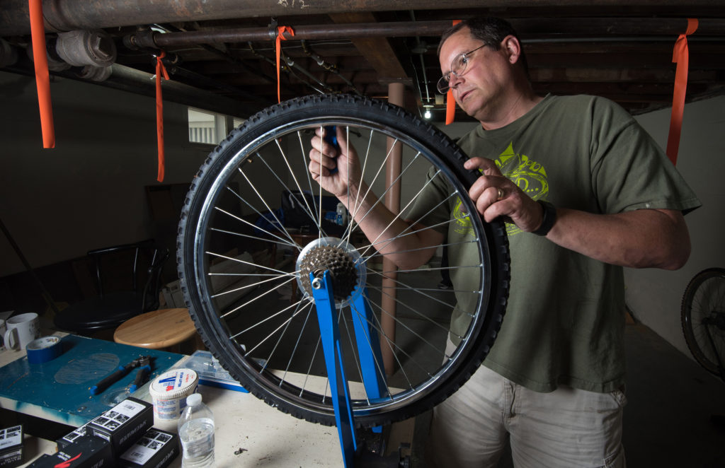 Tony Pichler, a member of the St. John the Evangelist Homeless Shelter's ministry team in Green Bay, Wis., repairs the inner tube on a bicycle tire June 7. Pichler and Paula Rieder, coordinator of pastoral ministry at St. Raphael the Archangel Parish in Oshkosh, Wis., were instrumental in launching Spokes 4 Hope. (CNS photo/Sam Lucero, The Compass) 