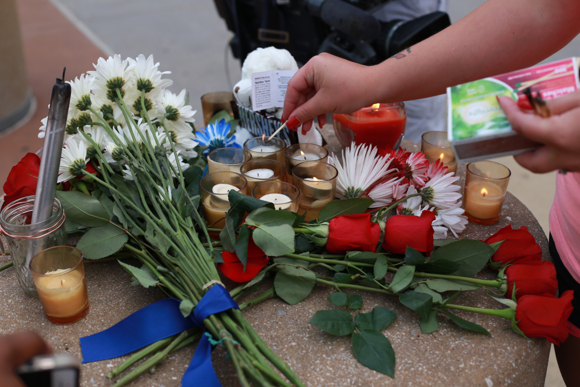 A woman lights a candle at a makeshift memorial outside of the Dallas Police Department headquarters in Dallas July 8. The prior evening gunmen shot and killed five police officers and wounded seven during a peaceful protest in downtown Dallas. The protest was in reaction after two black men were fatally shot by police officers in Baton Rouge, La., and Minneapolis. (CNS photo/Rebecca Kirstin Patton, The Texas Catholic)