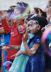 Syrian refugee children sing among floating bubbles during a graduation ceremony at the Latin Patriarchate School in Naour, Jordan, July 11. (CNS photo/Dale Gavlak) 