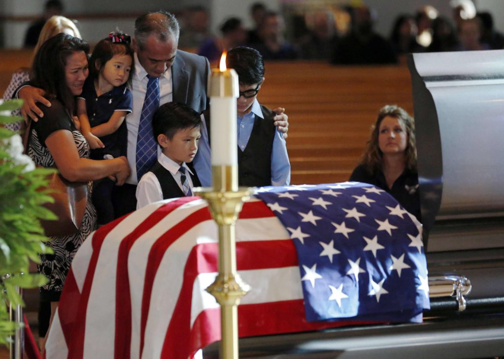 Billy Smith, brother of slain Dallas Police Sgt. Michael Smith, and his family grieve at the officer's casket during a July 12 visitation for him at Mary Immaculate Catholic Church in Farmers Branch, Texas. Smith, a member of the parish, was one of five officers killed when a gunman opened fire at a July 7 protest in downtown Dallas. (CNS photo/G.J. McCarthy, The Dallas Morning News pool via Reuters)
