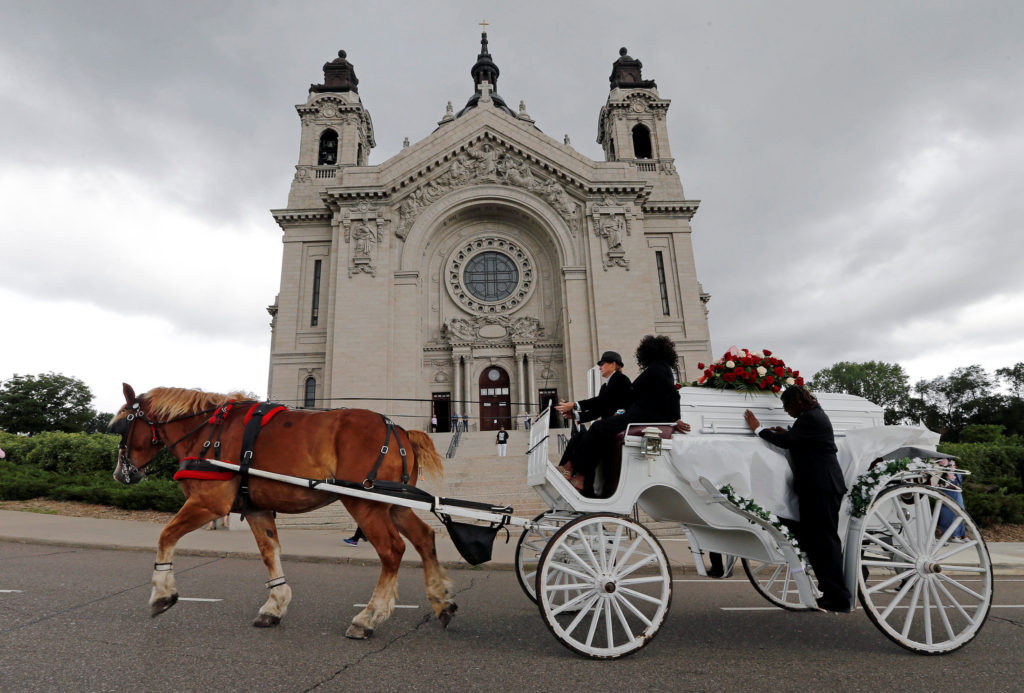 A horse-drawn carriage carries the casket of Philando Castile July 14 as it passes the Cathedral of St. Paul in St. Paul, Minn. Church officials say the mother of 32-year-old man, who was not Catholic, requested the cathedral hold an ecumenical funeral service for her son. Castile was shot and killed by a police officer July 6. (CNS photo/Eric Miller, Reuters) 