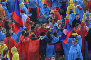 Pilgrims sing and dance in the rain prior to the opening Mass for World Youth Day July 26 at Blonia Park in Krakow, Poland. (CNS photo/Bob Roller) 