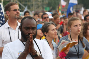 A pilgrim prays during the opening Mass for World Youth Day July 26 at Blonia Park in Krakow, Poland. (CNS photo/Bob Roller) 