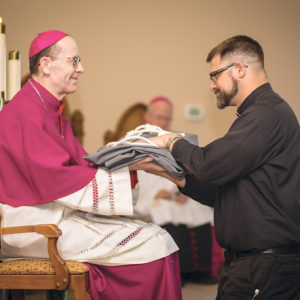 Fr. Alcuin Hurl, FHS, receives the new habit of the Franciscan Friars of the Holy Spirit from Bishop Thomas J. Olmsted. (Billy Hardiman/CATHOLIC SUN)