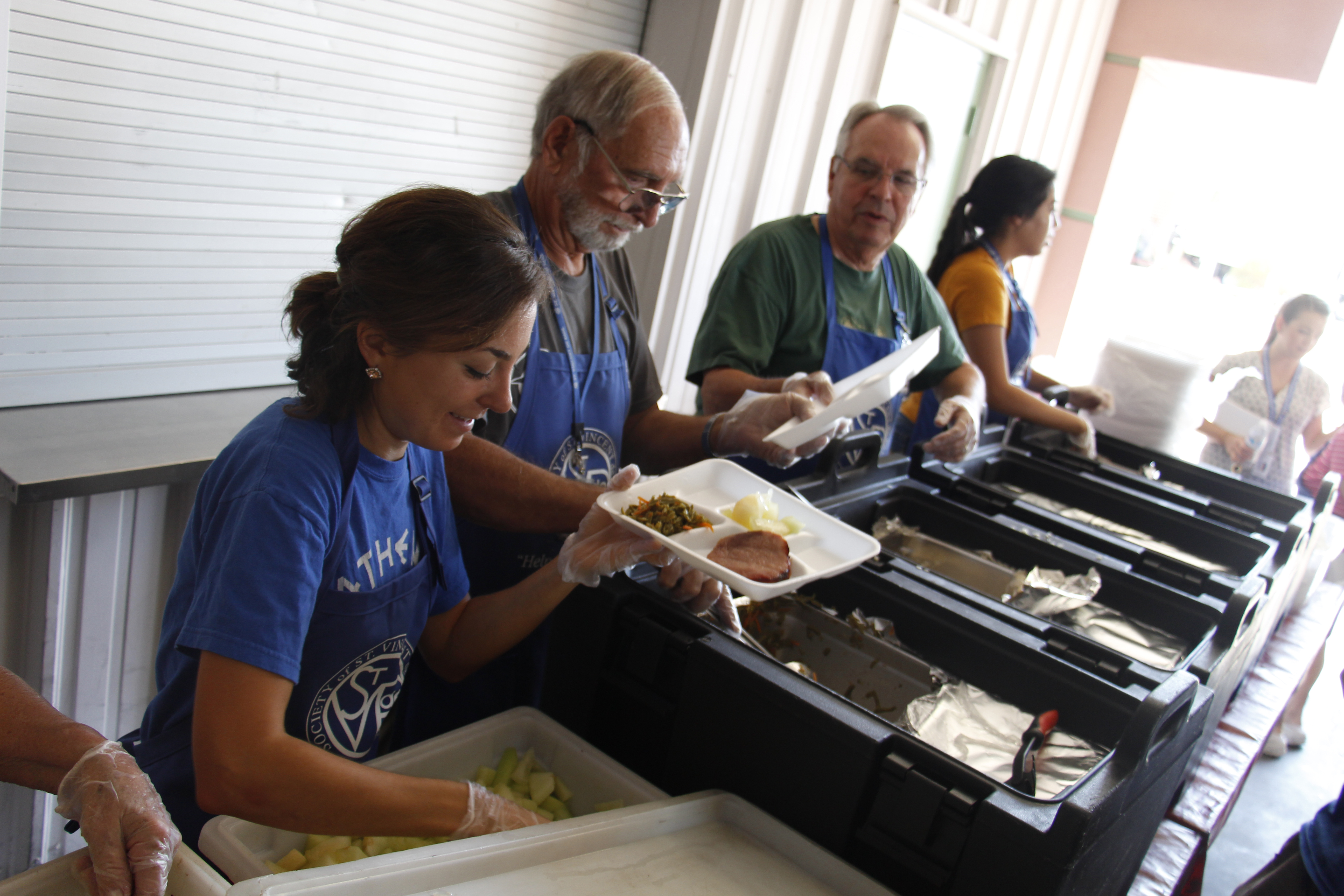Vincentians serve clients a meal July 7 at their temporary space provided by Paz de Cristo. (Ambria Hammel/CATHOLIC SUN)