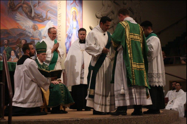 Dcn. Tim Seavey assists fellow seminarian and new Dcn. Frank Cicero with his stole and his alb June 19. (photo courtesy of St. Timothy Parish)