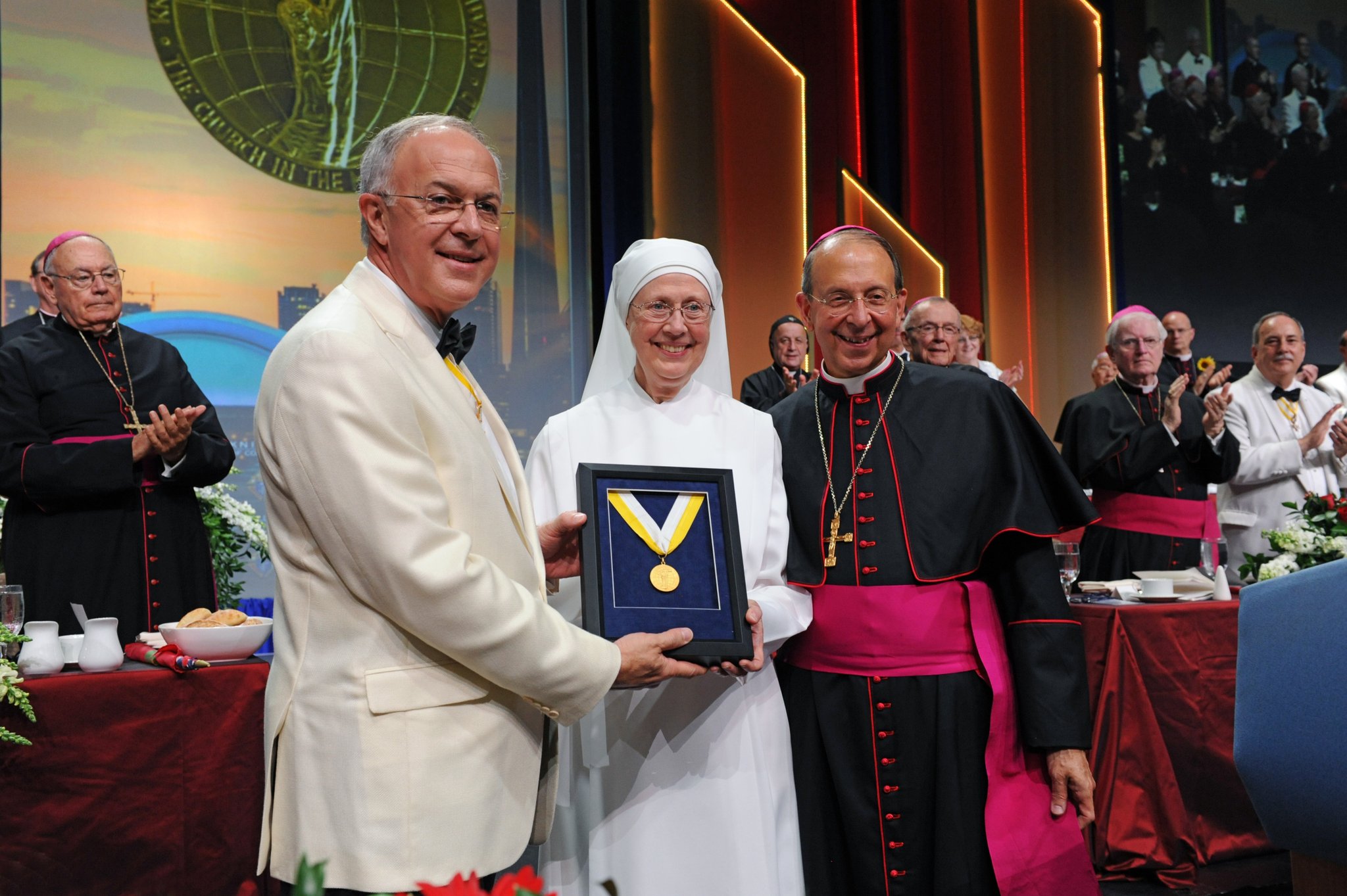 Mother Loraine Marie Maguire, superior of the Little Sisters of the Poor’s Baltimore province, receives the Gaudium et Spes Award, the Knights of Columbus’ highest honor, from Supreme Knight Carl A. Anderson and Supreme Chaplain Archbishop William E. Lori of Baltimore during the States Dinner at the Knights’ 134th annual convention. (Photo courtesy of the Knights of Columbus)