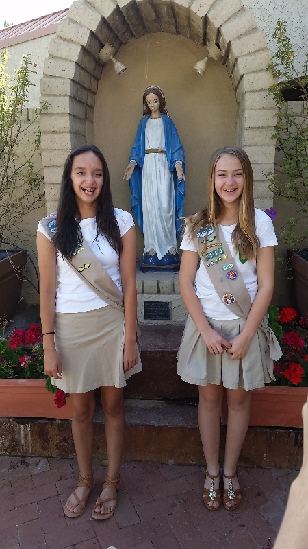Girl Scouts Cienna Jaime and Jacey Salisbury from Troop 1114 stand in front of a statue of Mary at Our Lady of Mount Carmel Parish in Tempe. (Photo courtesy of the Society of St. Vincent de Paul)