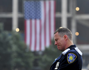 Daniel Henry, a Port Authority of New York/New Jersey police officer, pauses during a moment of silence at the 9/11 Memorial during 2013 ceremonies marking the anniversary of the 9/11 attacks on the World Trade Center in New York. The 2001 terrorist attacks claimed the lives of nearly 3,000 people in New York City, Shanksville, Pa., and at the Pentagon. (CNS photo/Stan Honda, pool via Reuters) (Sept. 11, 2013)