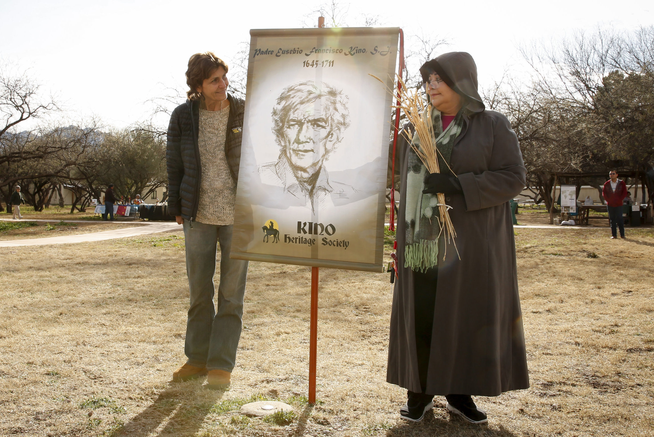 Carmen Dolny (left) and Rosie Garcia display a banner showing an image of Jesuit Father Eusebio Francisco Kino at the Tumacacori National Historical Park in Tumacacori, Ariz., Jan. 10. Fr. Kino was recently recognized as a model of mercy at a conference at the Vatican Sept. 24. (CNS photo/Nancy Wiechec)