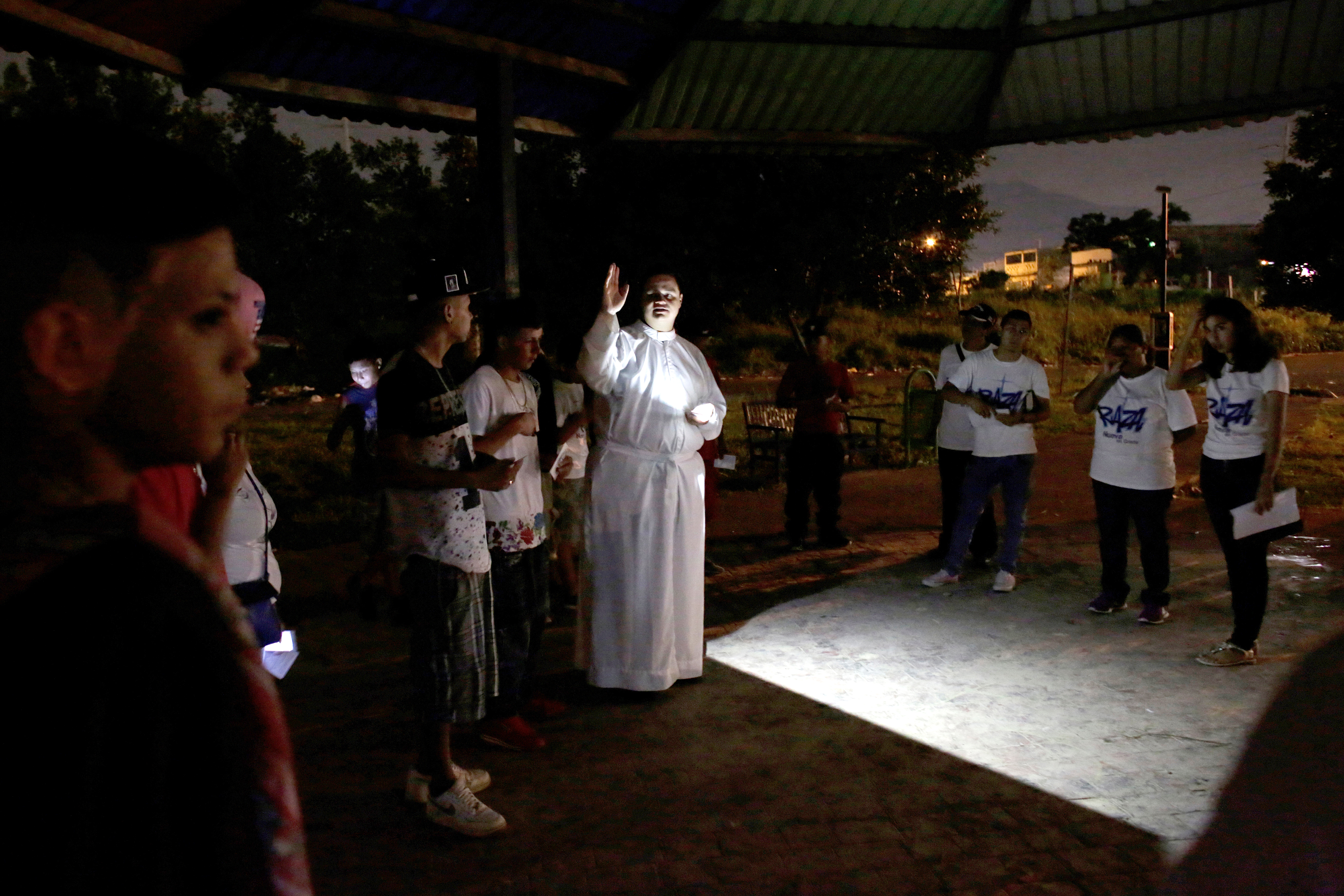 Fr. Jose Luis Guerra blesses young people during a visit to a neighborhood in Monterrey, Mexico. Father Guerra works with gang members with his own group, dubbed the Gang of Christ. (CNS photo/Daniel Becerril, Reuters)