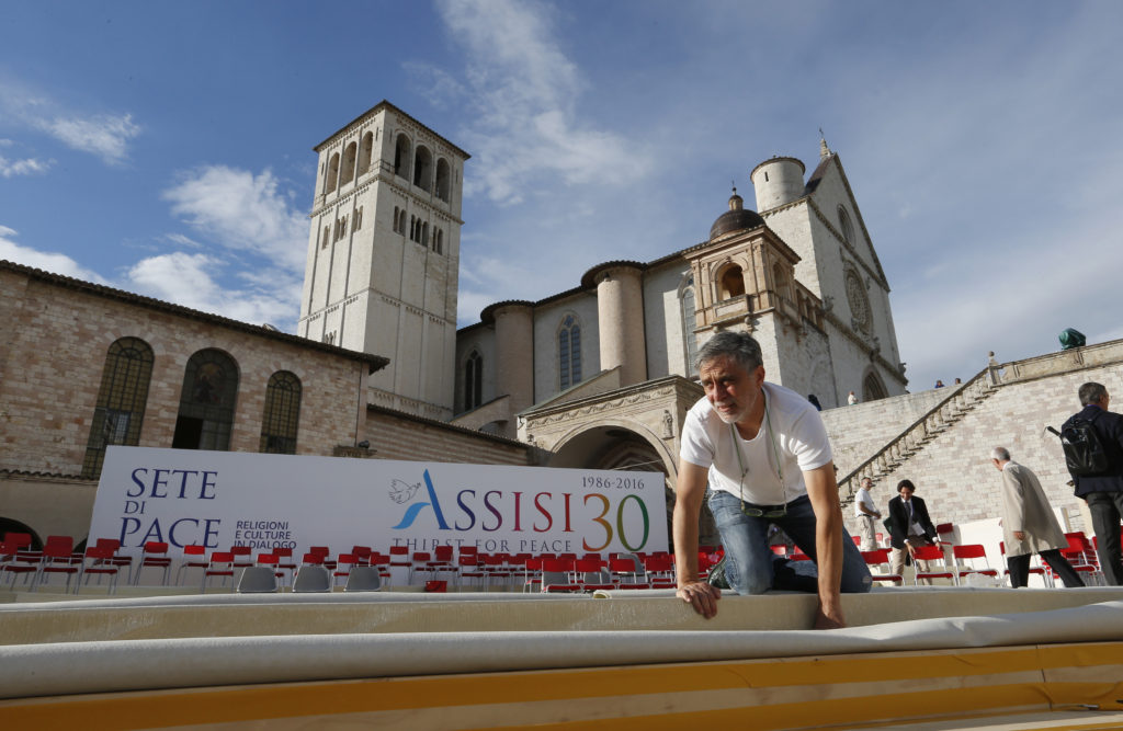 A worker helps prepare the stage for an interfaith peace gathering outside the Basilica of St. Francis in Assisi, Italy, Sept. 19. Pope Francis will attend the Sept. 20 peace gathering marking the 30th anniversary of the first such gathering in Assisi. (CNS photo/Paul Haring) 