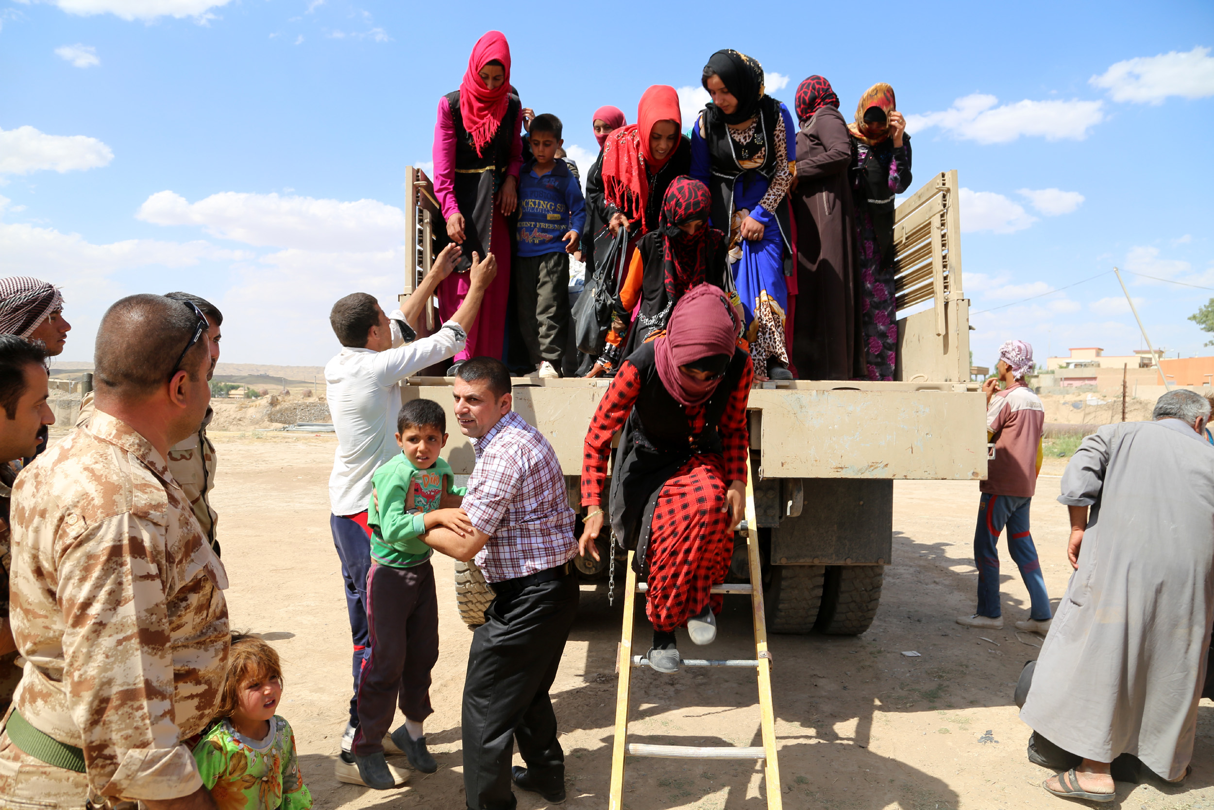 Families displaced by violence arrive in early June at a temporary shelter in Kirkuk, Iraq. Chaldean Catholic bishops, meeting for their annual synod in Irbil, Iraq, pleaded for peace in the Middle East and for the liberation of areas seized by the Islamic State so that the displaced can return to their homes. (CNS photo/EPA)