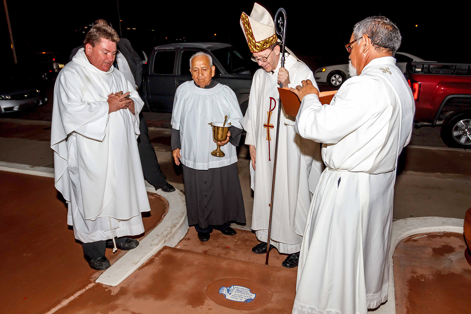 Bishop Thomas J. Olmsted admires a tile marking the spot where Mother Teresa kissed the ground outside Our Lady of Fatima Mission when she got out of her car in 1989. (John Bering/CATHOLIC SUN)