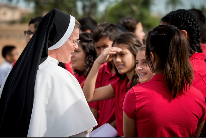 Principal Sr. Mary Jordan Hoover, OP, meets with St. John Vianney students during the site blessing for St. John Paul II Catholic High School April 5. (Billy Hardiman/CATHOLIC SUN)