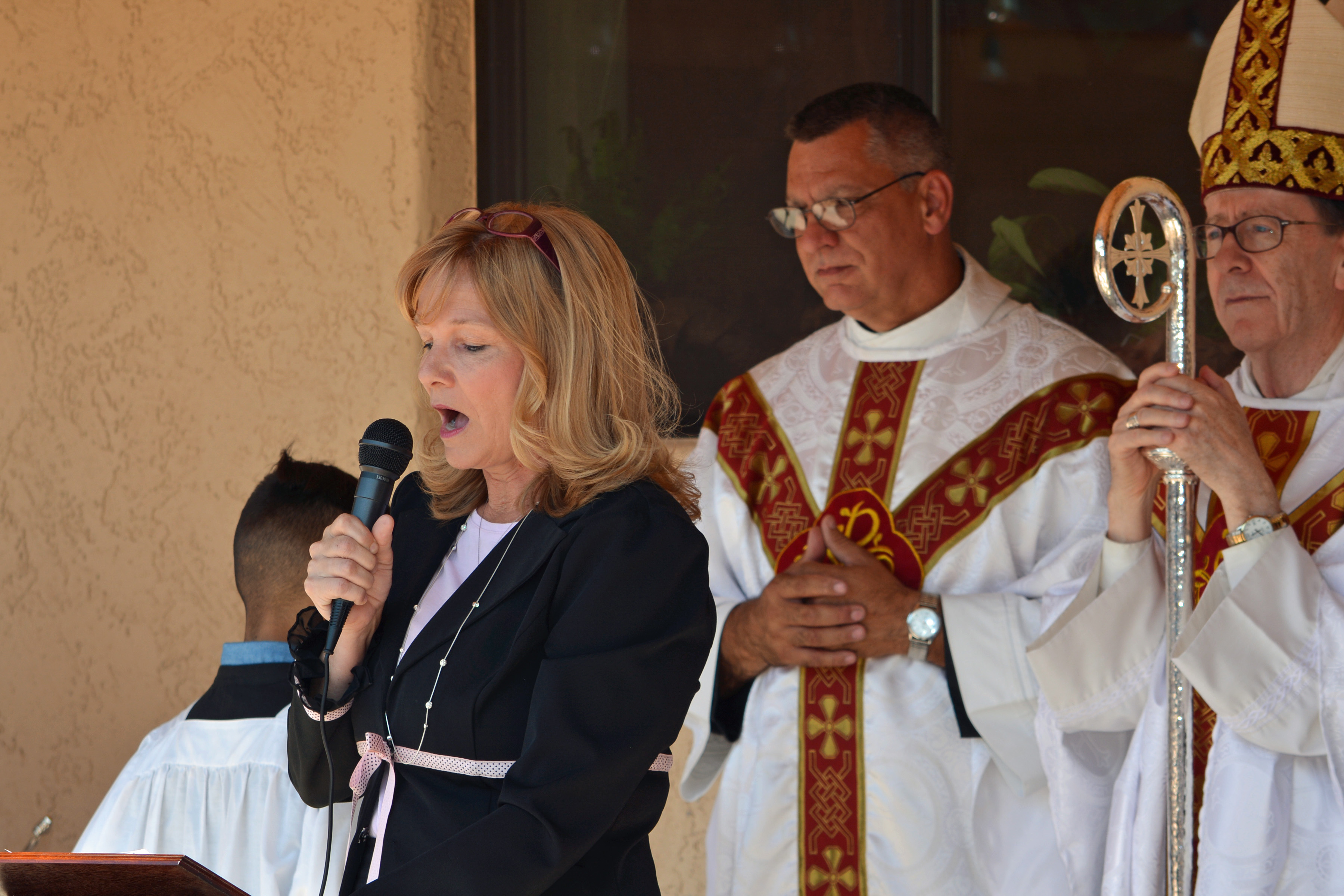 Jackie Kirkham, principal of St. Joseph/Immaculate Conception School, speaks at the school’s blessing ceremony on Sept. 18. Fr. David Kelash, left, pastor of Immaculate Conception Parish in Cottonwood, and Bishop Thomas J. Olmsted accompany her. (Lisa Dahm/CATHOLIC SUN)